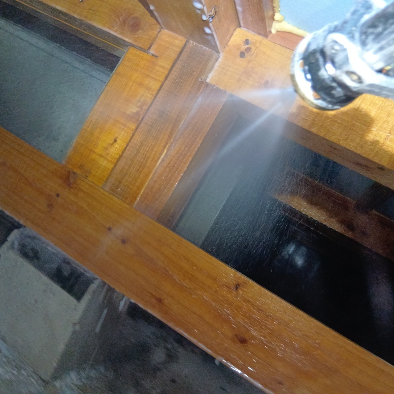 床下木材にシロアリ駆除剤を散布している様子