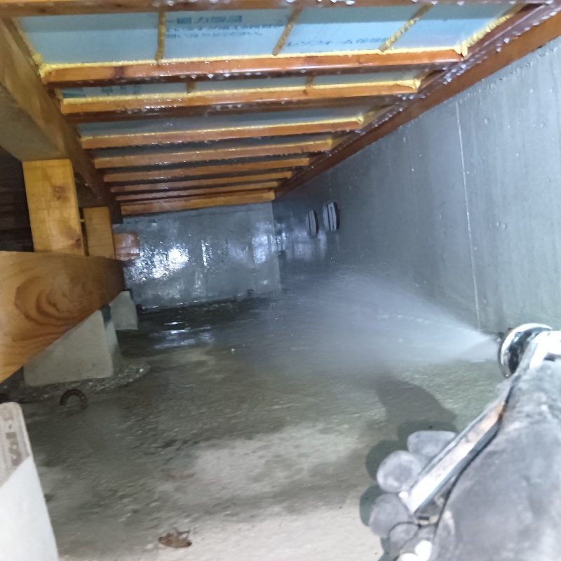 地面にシロアリ駆除剤を散布している様子