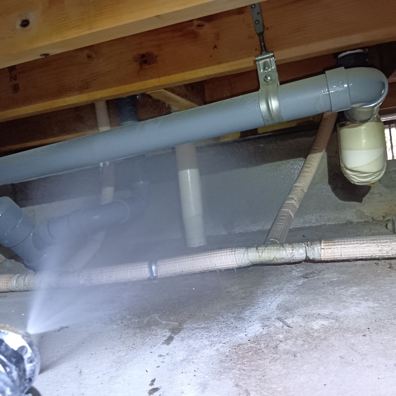 地面に防蟻剤を吹きつける様子