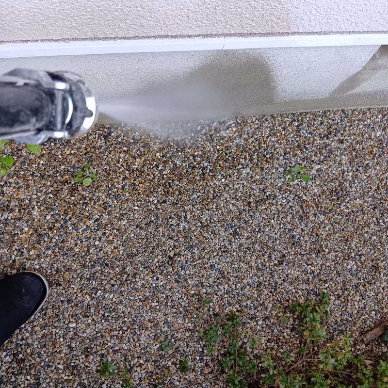 建物外周の土壌に防蟻剤を吹きつける様子