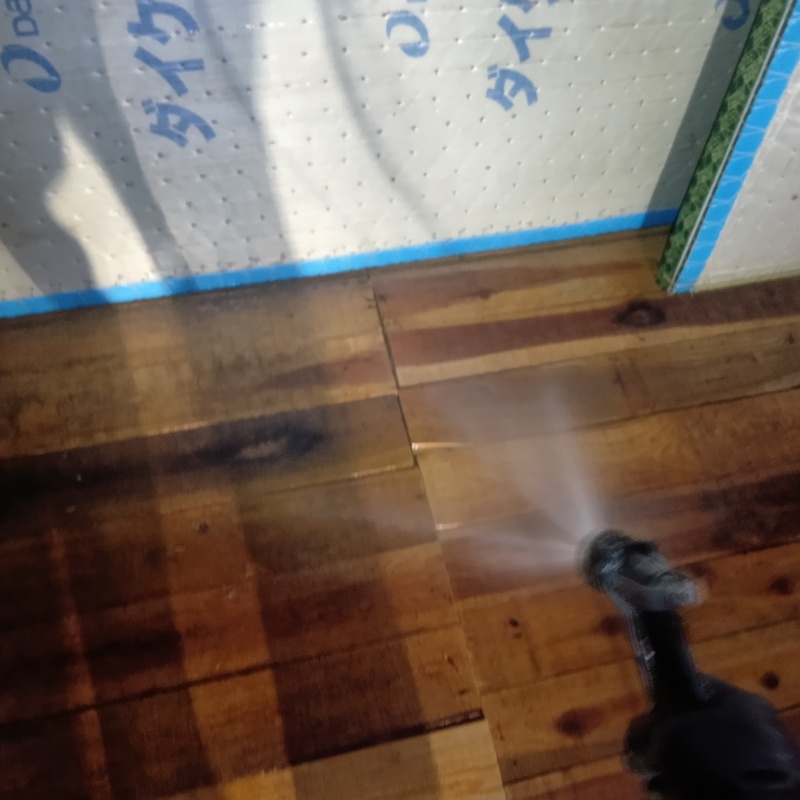 床板にシロアリ駆除剤を吹き付ける様子