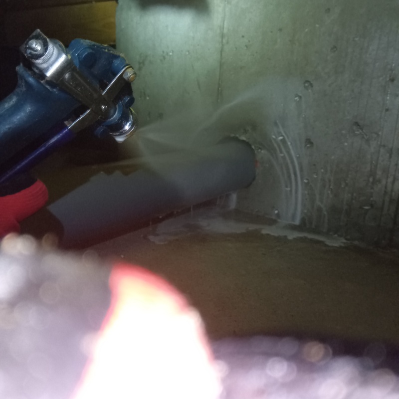 基礎にシロアリ駆除剤を吹きつける様子