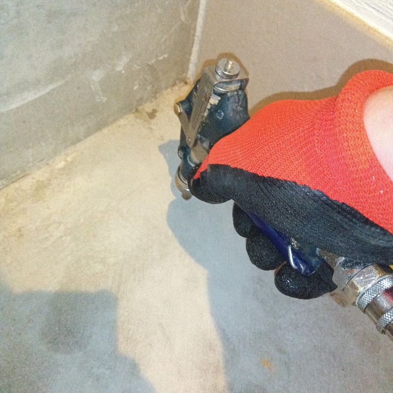 玄関床のコンクリートにシロアリ駆除剤を注入する様子