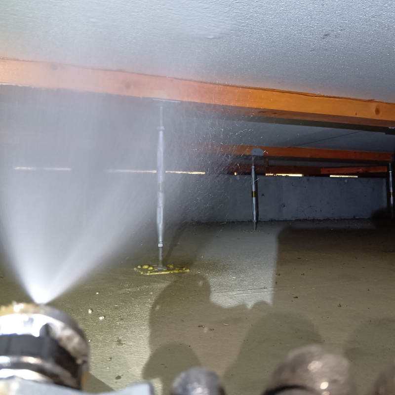 床下木材に防蟻剤を吹きつける様子