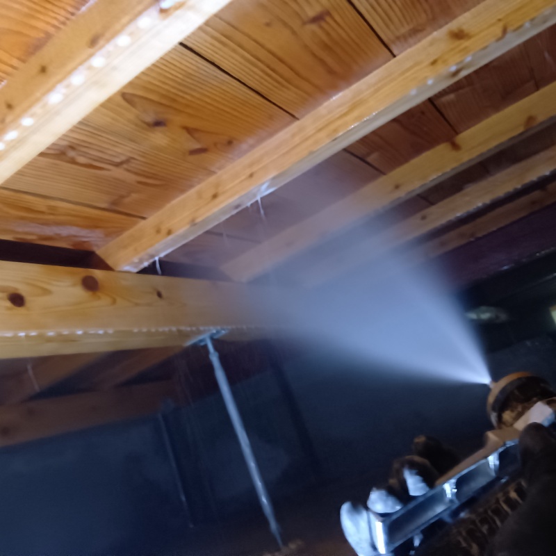 床下木材に防蟻剤を吹き付ける様子