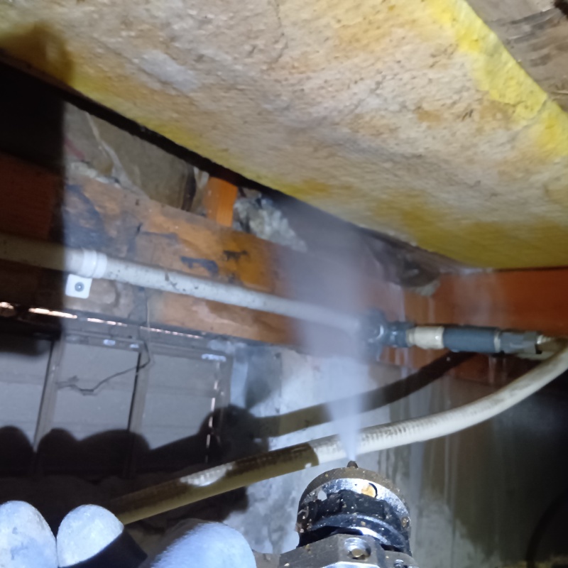 床下木材にシロアリ駆除剤を吹き付ける様子