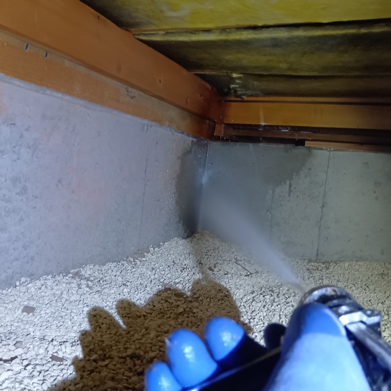 基礎にシロアリ駆除剤を吹き付ける様子