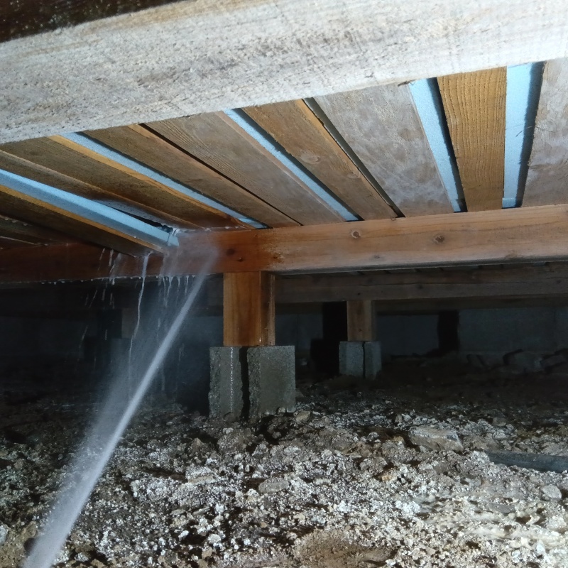 床下断熱材にシロアリ駆除剤を吹き付けている様子