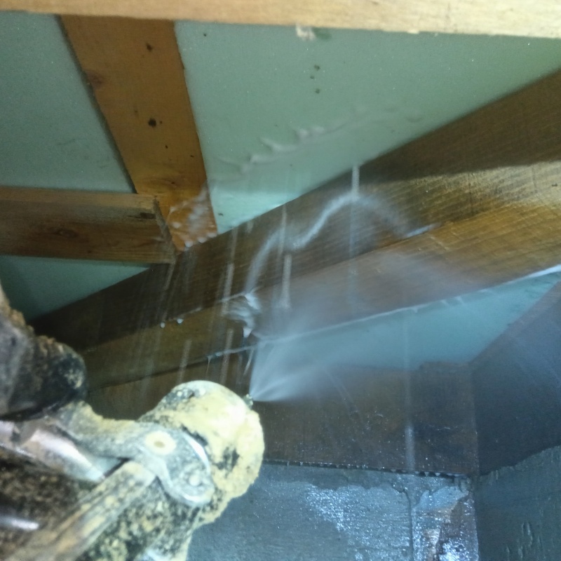 床下断熱材に防蟻剤を吹き付ける様子