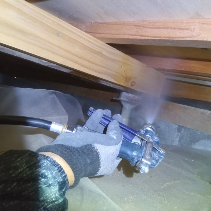 床下木材にシロアリ駆除剤を散布する様子