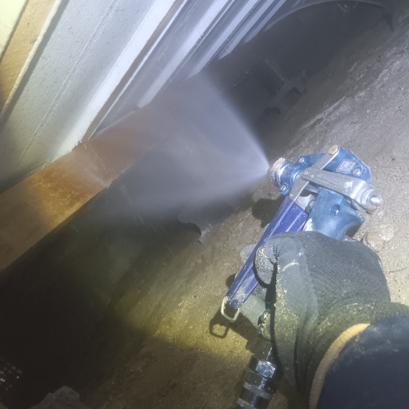 床下断熱材にシロアリ駆除剤を吹き付ける様子