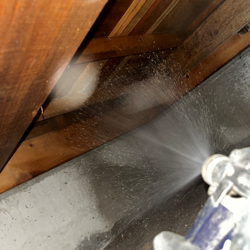 床下木材に防蟻剤を吹き付ける様子