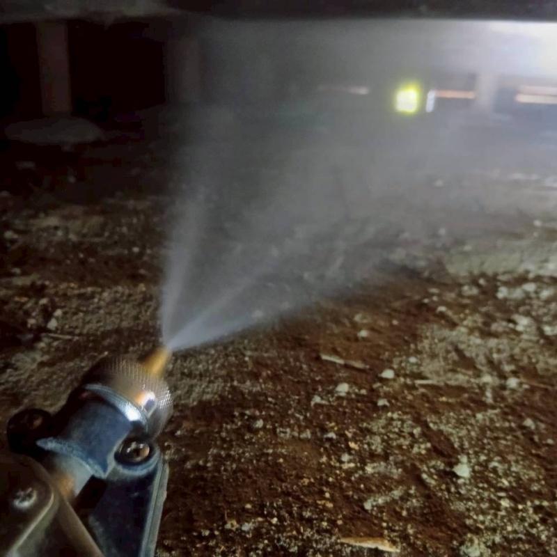 地面にシロアリ駆除剤を吹き付けている様子