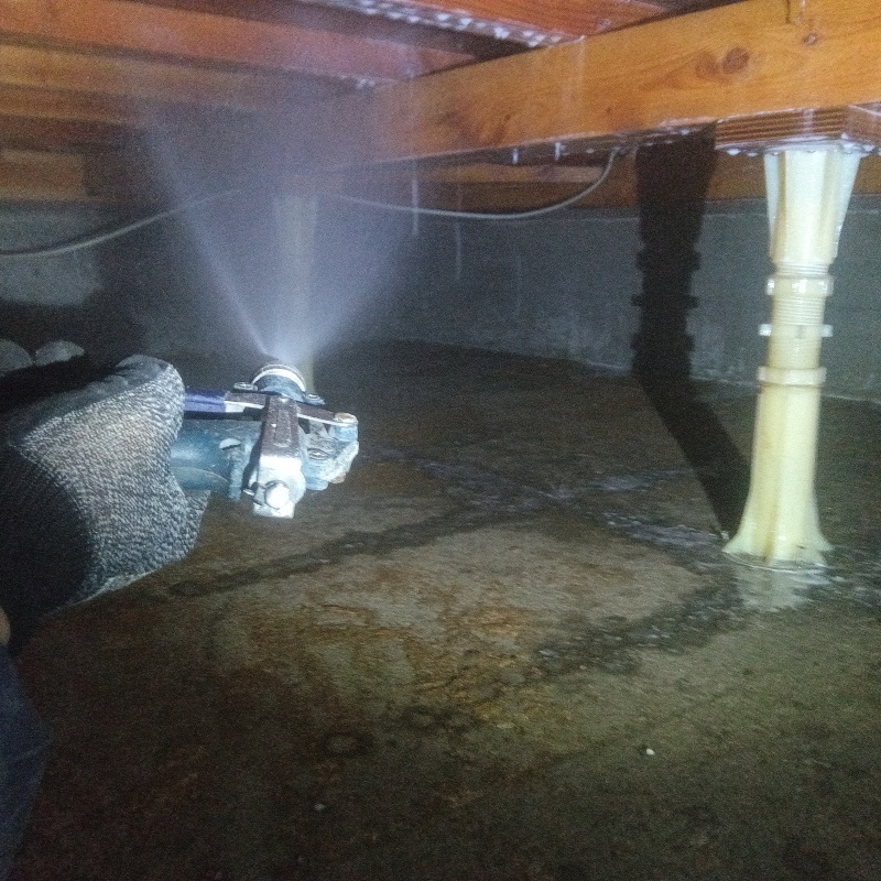 床下木材にシロアリ駆除剤を吹き付ける様子