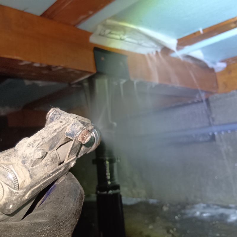 床下断熱材に防蟻剤を吹き付ける様子