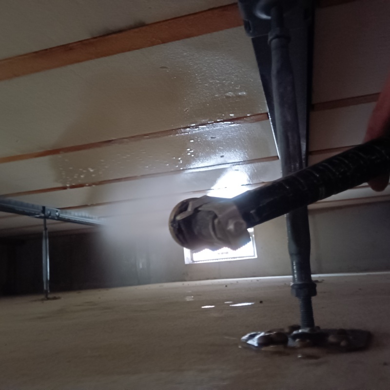 床下断熱材に防蟻剤を吹き付ける様子