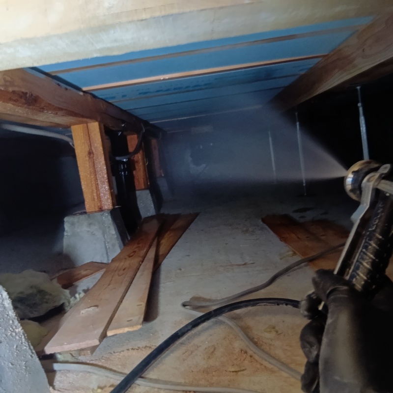 床下断熱材にシロアリ駆除剤を吹き付ける様子