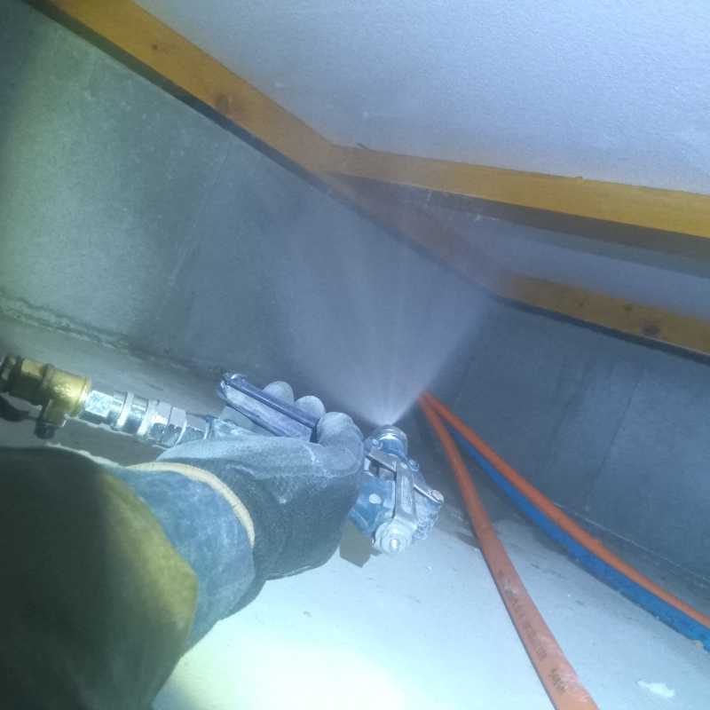 床下断熱材に防蟻剤を吹き付ける様子