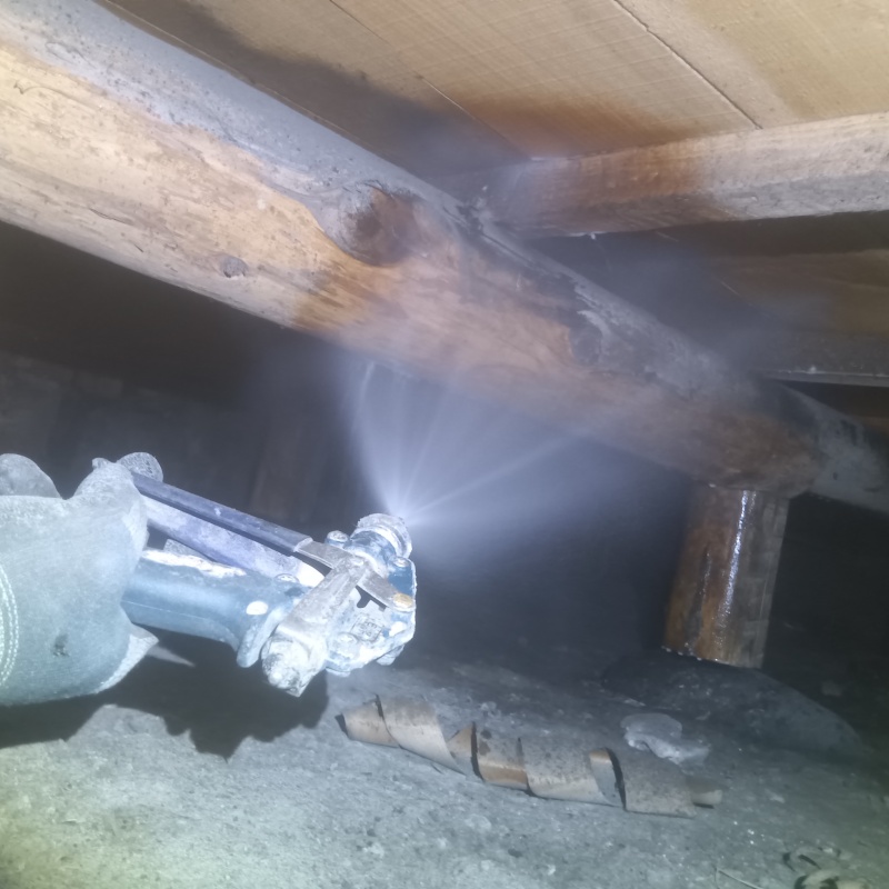 床下木材にシロアリ駆除剤を吹き付ける様子