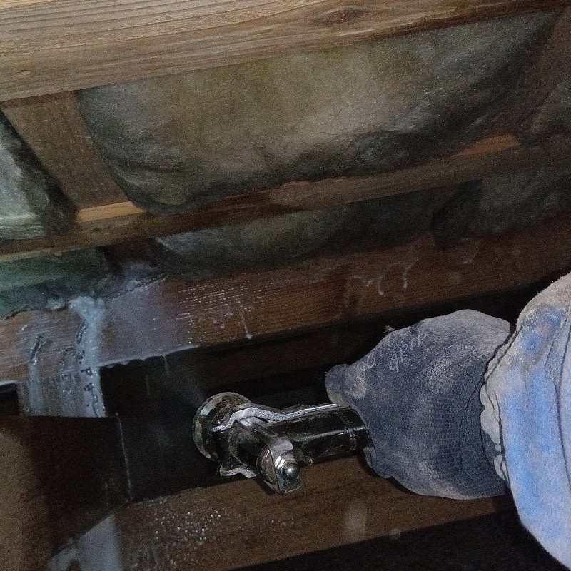 床下断熱材にシロアリ駆除剤を吹き付ける様子