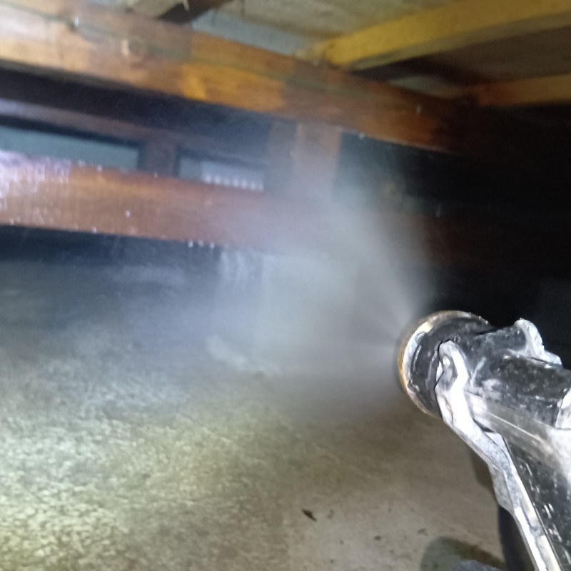 床下木材にシロアリ駆除剤を吹き付ける様子