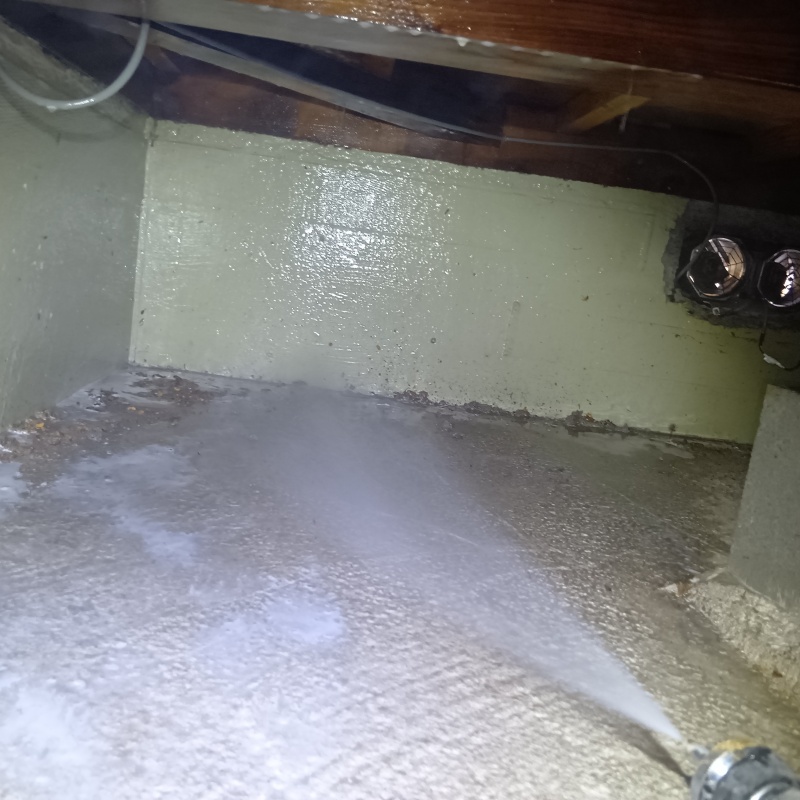 地面にシロアリ駆除剤を吹き付ける様子