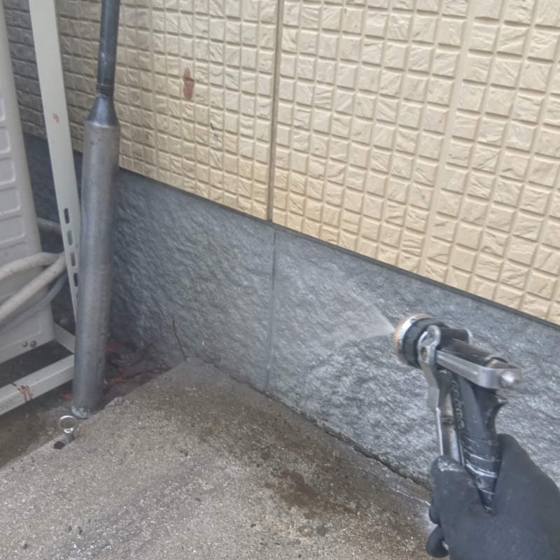 基礎まわりにシロアリ駆除剤を散布する様子