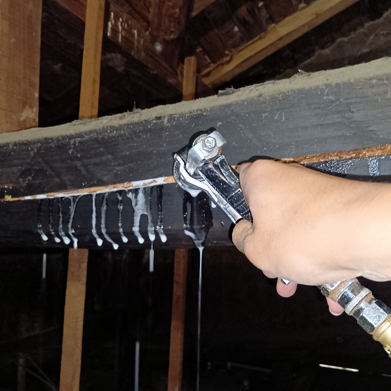 屋根裏の梁にシロアリ駆除剤を散布