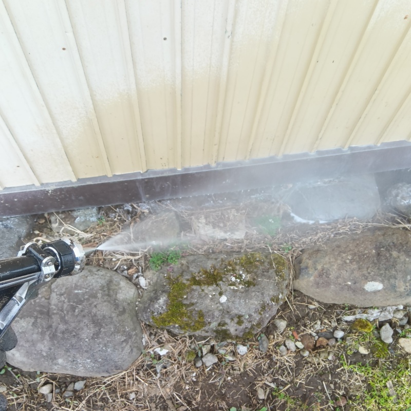 建物外周の土壌にシロアリ駆除剤を吹き付ける様子