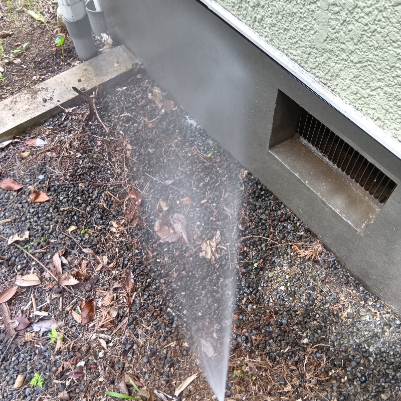 建物外周の土壌にシロアリ駆除剤を吹き付ける様子