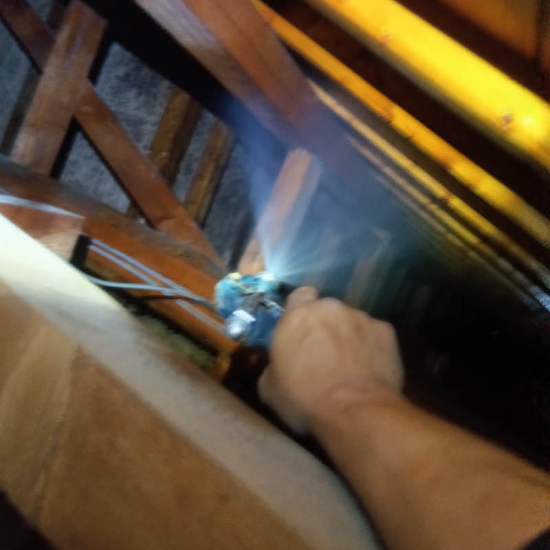 屋根裏の木材にシロアリ駆除剤を散布