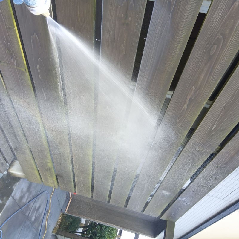 木塀にシロアリ駆除剤を吹き付ける様子