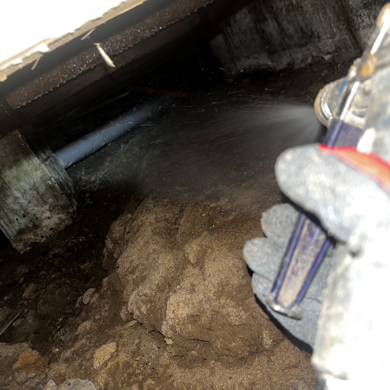 地面にシロアリ駆除剤を吹き付ける様子