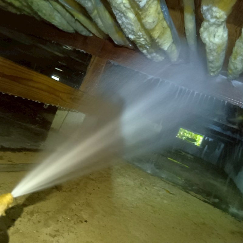 床下の木材にシロアリ駆除剤を散布する様子