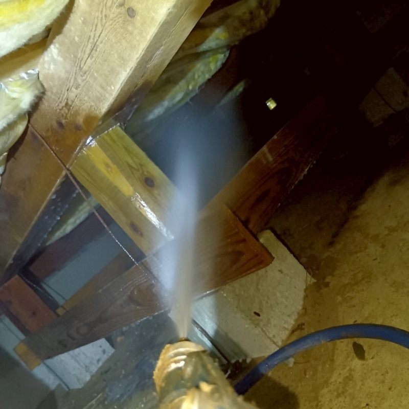 床下の木材にシロアリ駆除剤を散布する様子