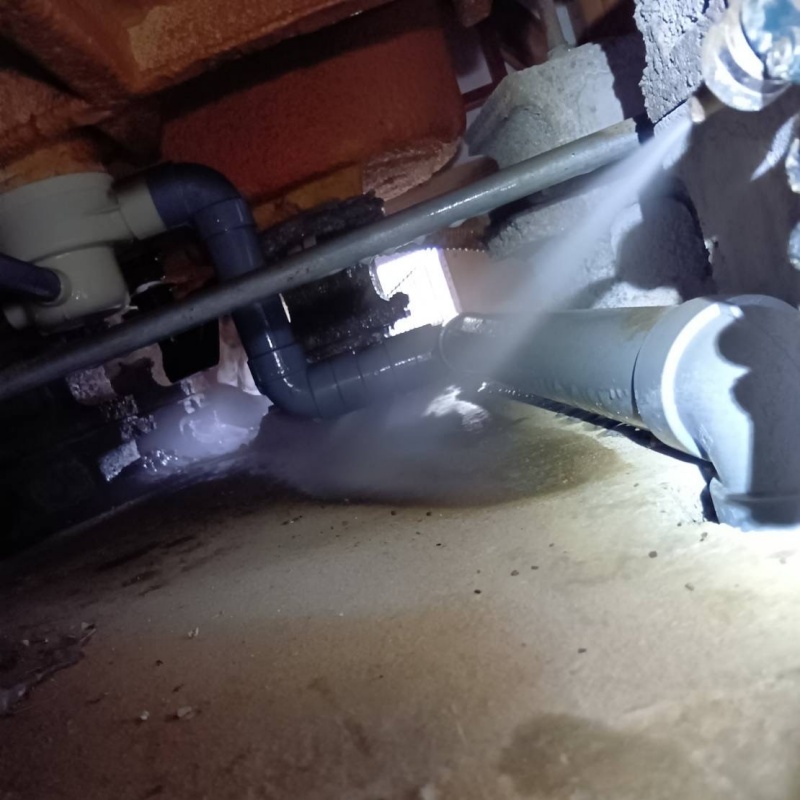 床下の土壌にシロアリ駆除剤を散布する様子