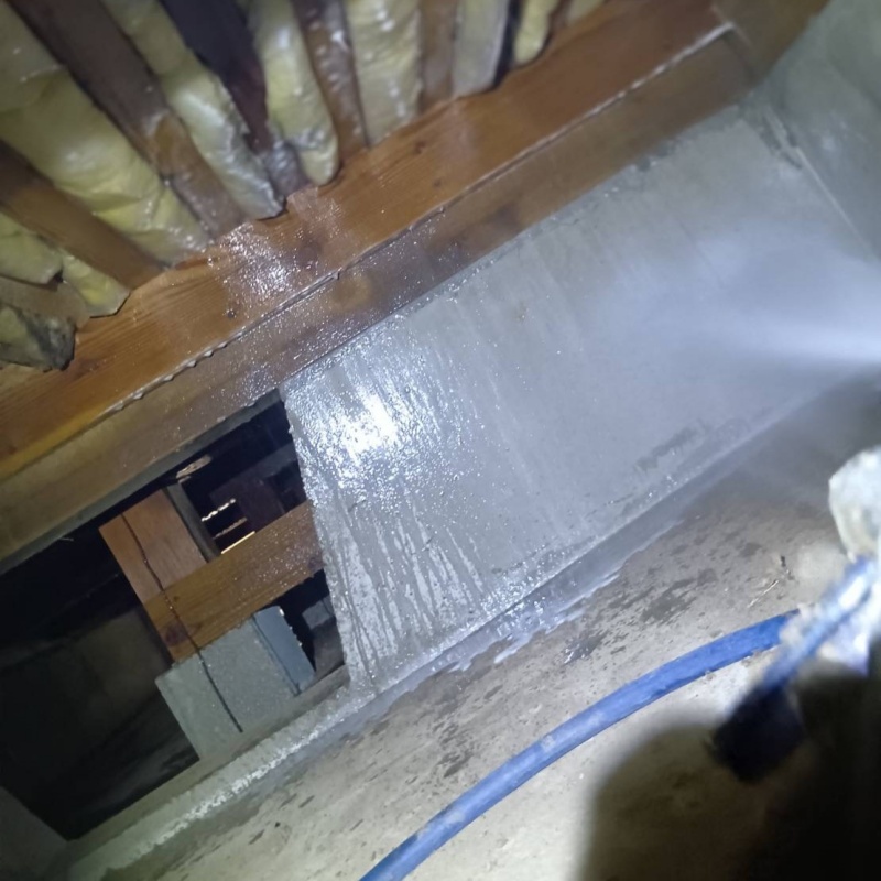 床下の基礎部分にシロアリ駆除剤を散布する様子