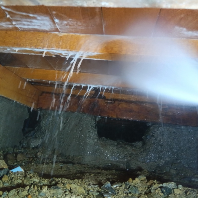 床下の木材にシロアリ駆除剤を散布する様子