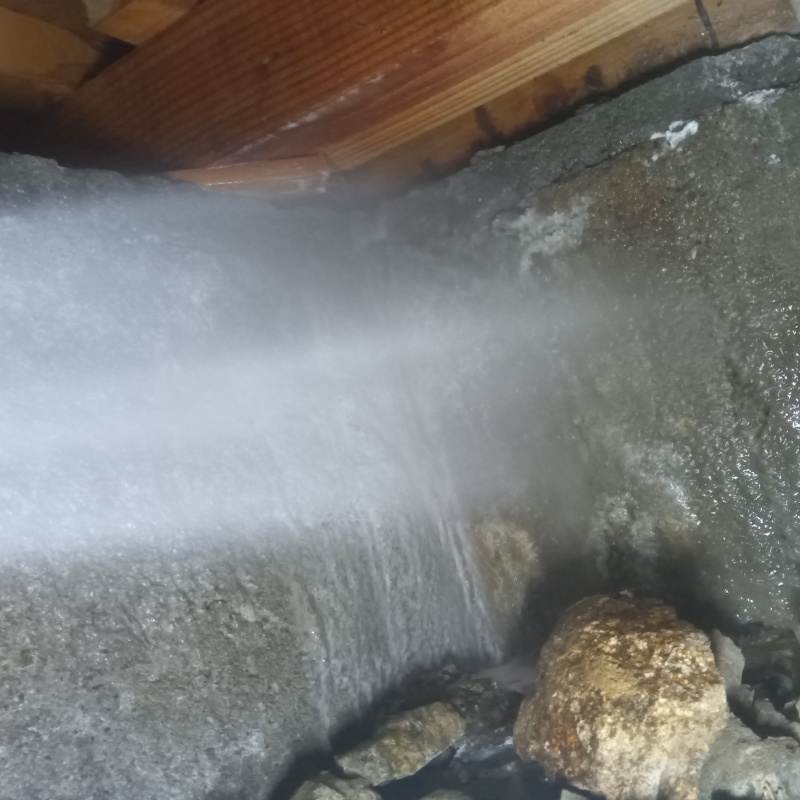 床下の基礎部分にシロアリ駆除剤を散布する様子