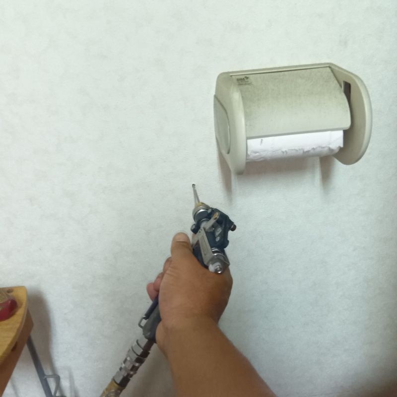 トイレの壁にシロアリ駆除剤を注入する様子
