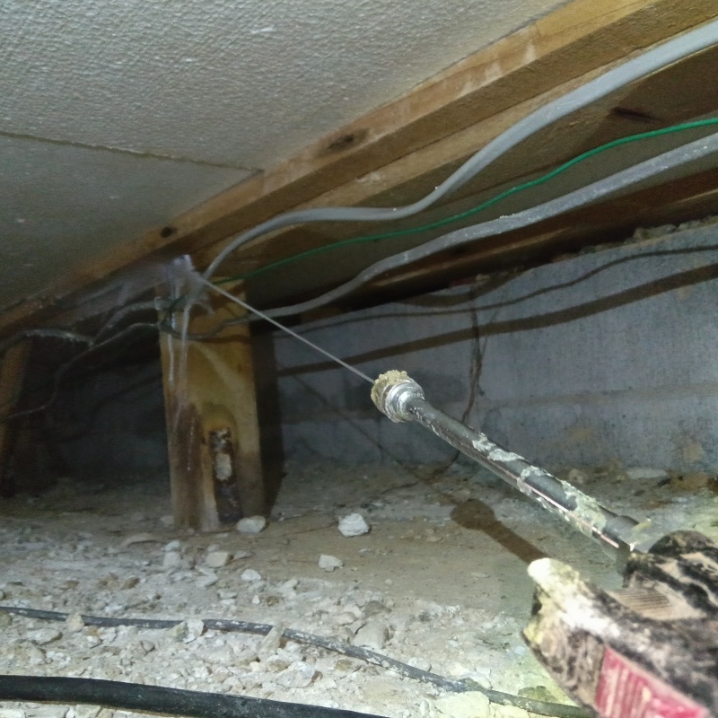 床下の木材にシロアリ駆除剤を散布する様子