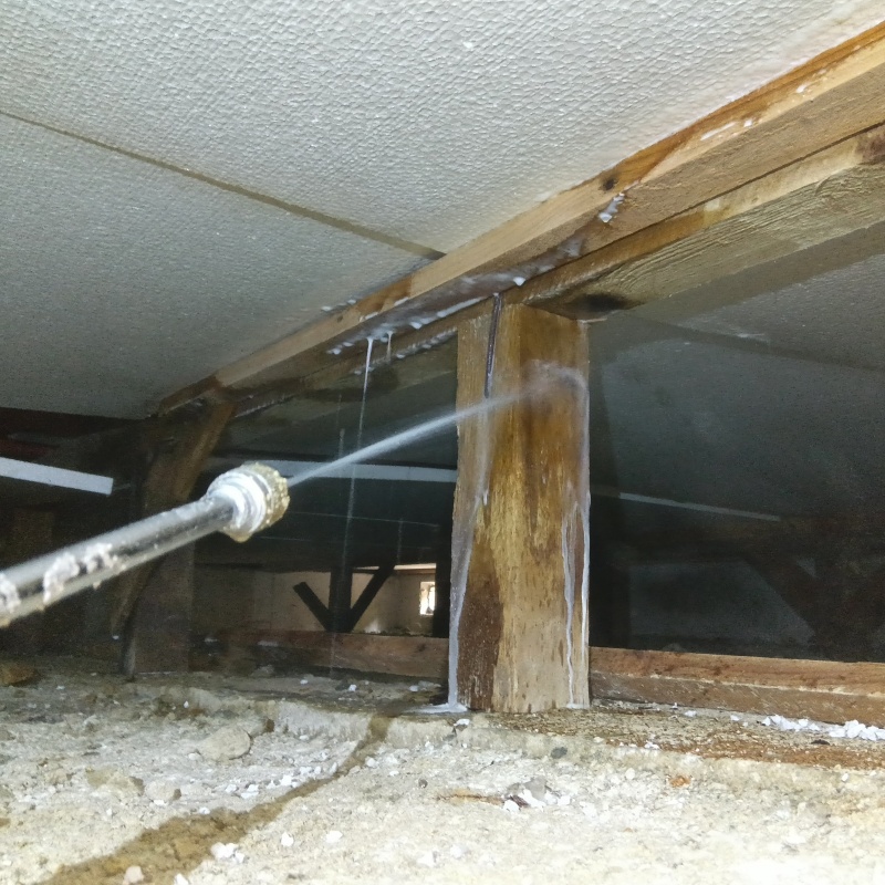 床下の木材にシロアリ駆除剤を散布する様子