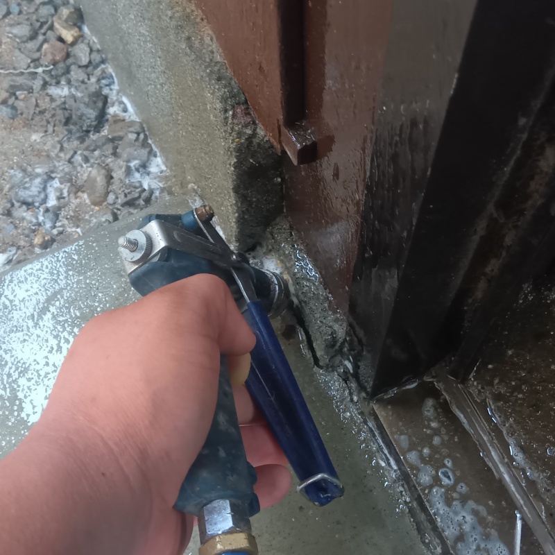 玄関の床にシロアリ駆除剤を注入する様子