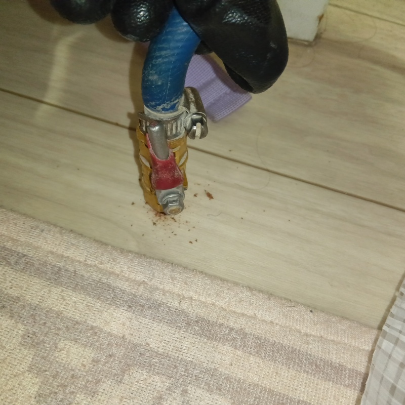 キッチンの床にシロアリ駆除剤を注入する様子