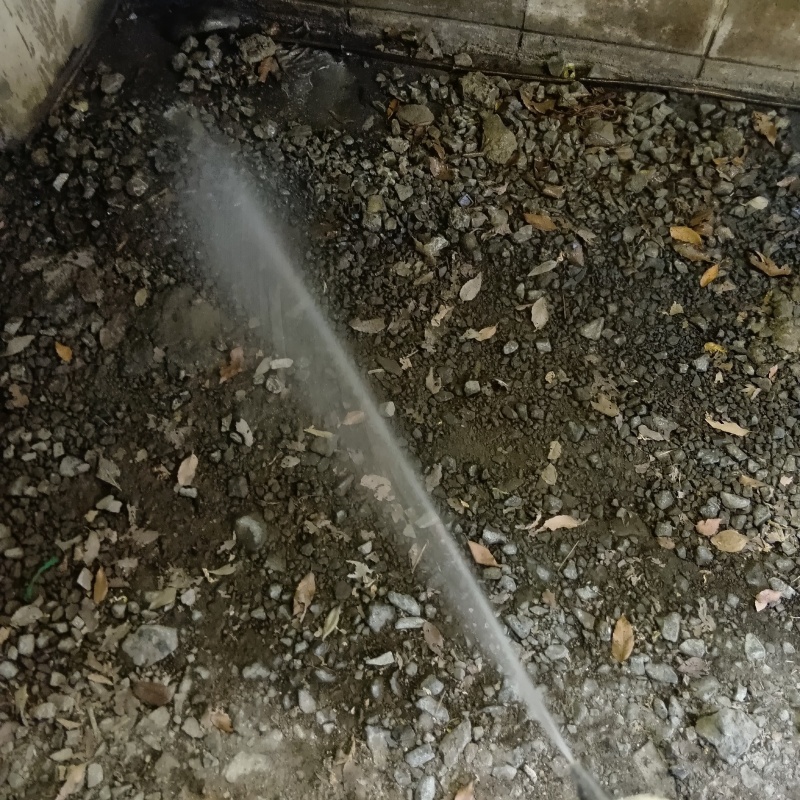 基礎まわりの土壌にシロアリ駆除剤を散布する様子