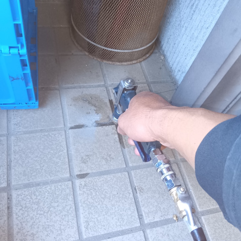 玄関の床にシロアリ駆除剤を注入する様子