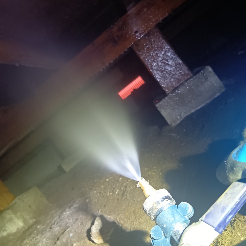 床下の木材にシロアリ駆除剤を散布する様子