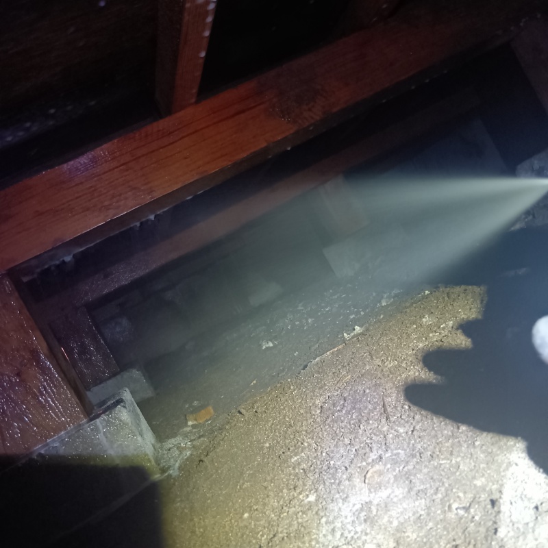 床下の土壌にシロアリ駆除剤を散布する様子