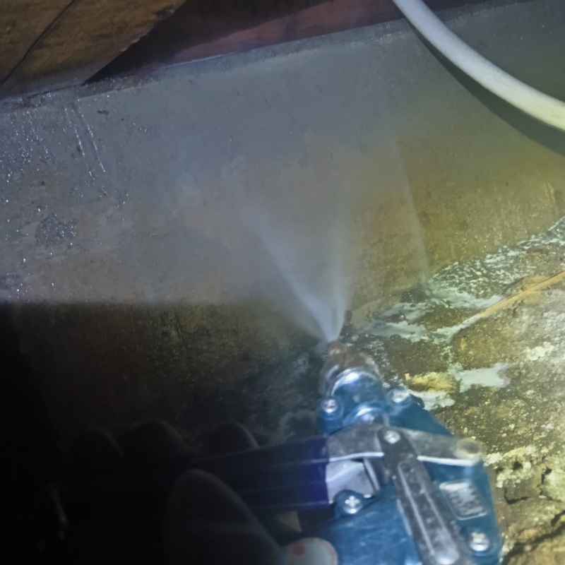 床下の基礎部分にシロアリ駆除剤を散布する様子