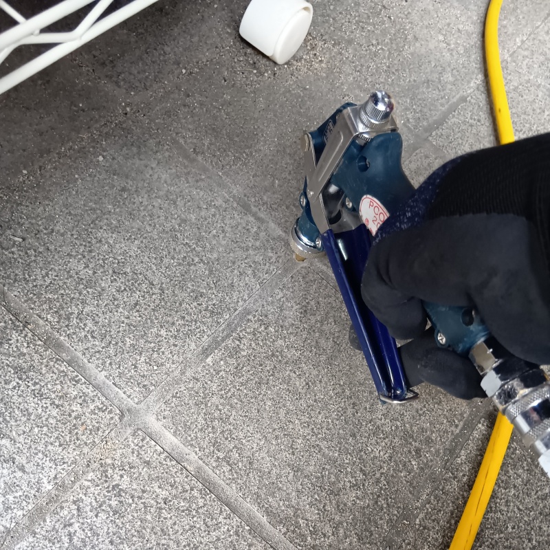 玄関の床にシロアリ駆除剤を注入する様子